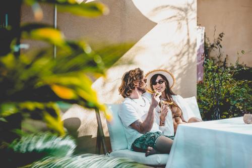 a man and a woman sitting next to a table at Dolphin Village - Sea Resort By Ran Hotels in Shave Ẕiyyon