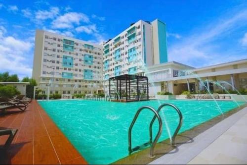 a large swimming pool in front of a building at DaLei 3-103 Sleeps 6pax at Marina Spatial Condominium in Dumaguete City in Dumaguete