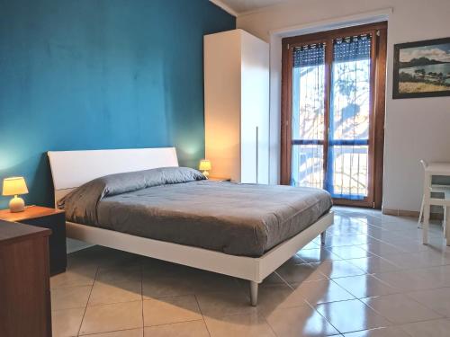 a bedroom with a large bed with a blue wall at Ronf & Gnam GALIMBERTI in Turin