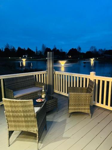 a deck with wicker chairs and a table with a table at Lakeside Escape with Hot Tub in York
