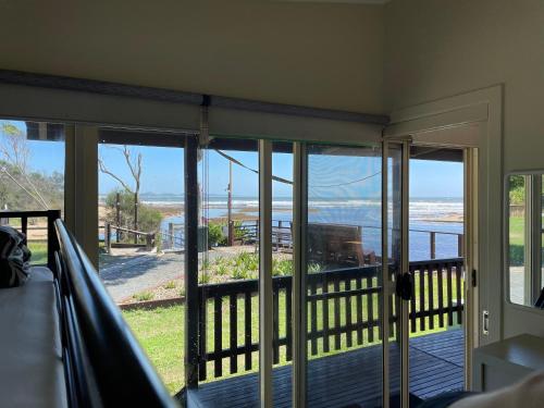 a screened in porch with a view of the ocean at The Beach Arrawarra in Arrawarra