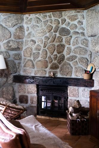 a stone fireplace in a room with a stone wall at Casa de Fora in Fafe