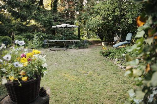 a picnic table and bench in a garden with flowers at Warmiński dom nad jeziorem in Łomy