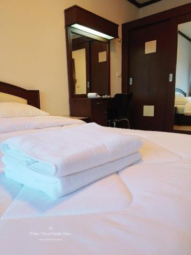 two towels sitting on a bed in a hotel room at White Cloud Family Suite in Ban Kohong