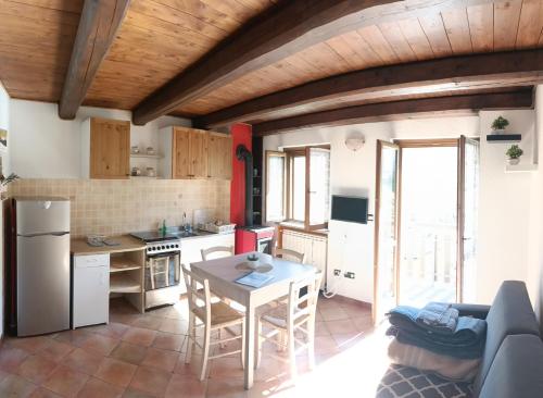 a kitchen with a table and a kitchen with a refrigerator at Casa Nicole Valle Stura in Demonte