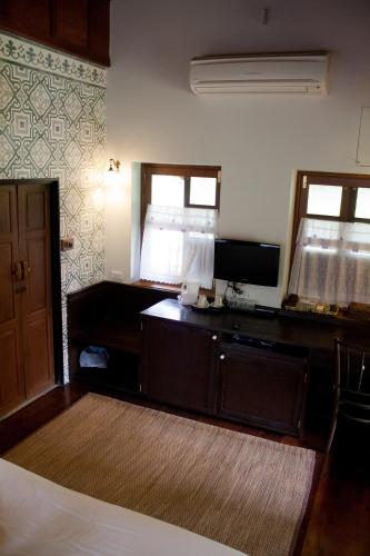 a room with a bed and a desk with a mirror at Ayodhara Village in Phra Nakhon Si Ayutthaya