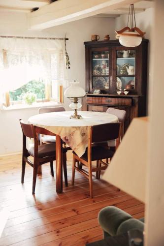 a dining room with a table and chairs and a window at Warmiński dom nad jeziorem in Łomy