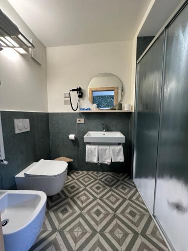 a bathroom with a toilet and a sink and a tub at Garni La Casetta in Livigno