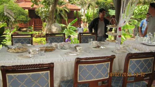 uma mesa com uma toalha de mesa branca com comida em Ayodhara Village em Phra Nakhon Si Ayutthaya