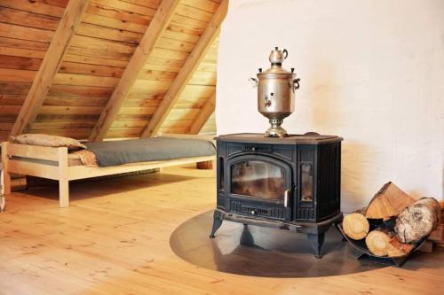 a wood stove in a room with a bed at Warmiński dom nad jeziorem in Łomy