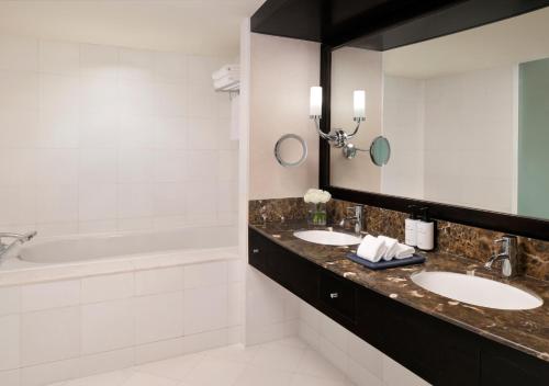a bathroom with two sinks and a tub at InterContinental Abu Dhabi by IHG in Abu Dhabi