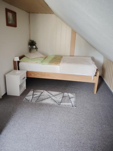 a small bedroom with a bed and a night stand at Ferienhaus Schlenker in Neustadt in Sachsen