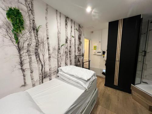 - une chambre ornée d'une fresque murale représentant des arbres dans l'établissement Batignolles, Montmartre Chambre 12m2 , Metro 13 et 14, à Paris