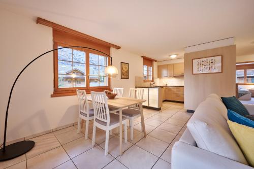 a living room with a couch and a table and chairs at Apartment Mountain View, Luxury, Spacious with best Views in Lauterbrunnen