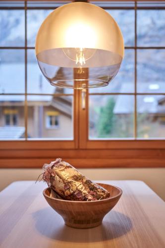 a lamp on top of a table with a bowl of corn at Apartment Mountain View, Luxury, Spacious with best Views in Lauterbrunnen