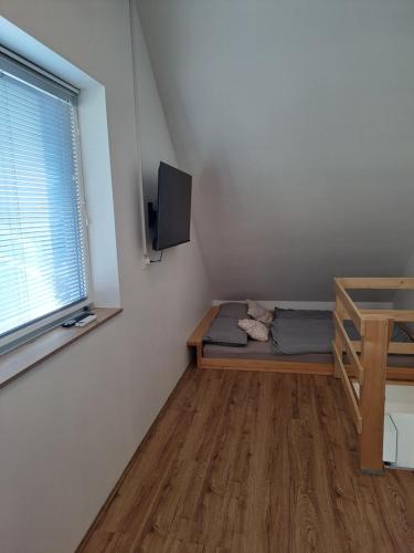a room with a bed and a desk and a window at Bella Apartment in Žirovnica