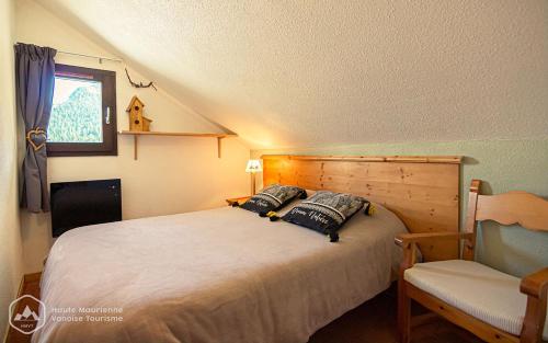 une chambre avec un grand lit et une chaise dans l'établissement L'Escapade, à Valfréjus