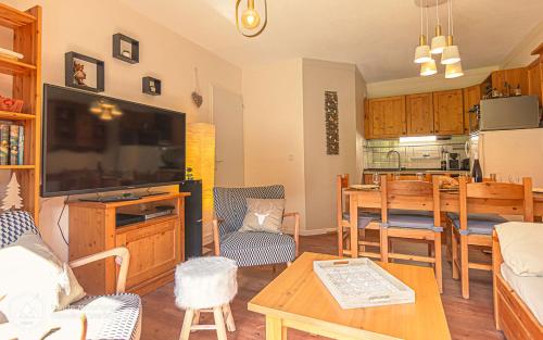 un salon avec une télévision et une salle à manger dans l'établissement L'Escapade, à Valfréjus