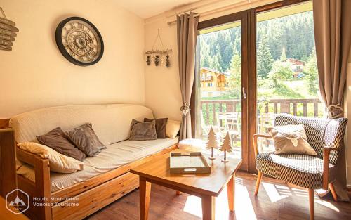 un salon avec un canapé et une table dans l'établissement L'Escapade, à Valfréjus