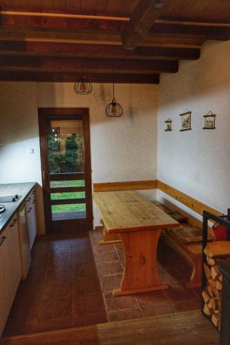 a kitchen with a wooden table in a room at Apartmani Novakovic in Bajina Bašta