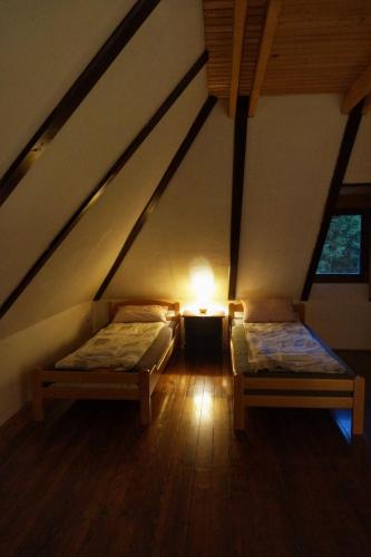 a attic room with two beds and a light in it at Apartmani Novakovic in Bajina Bašta