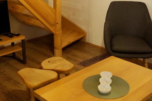 a living room with a table and a chair at Apartmani Novakovic in Bajina Bašta