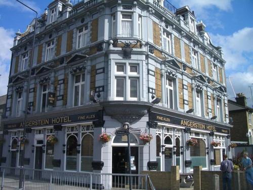 um grande edifício branco com pessoas de pé na frente dele em The Angerstein Hotel em Londres