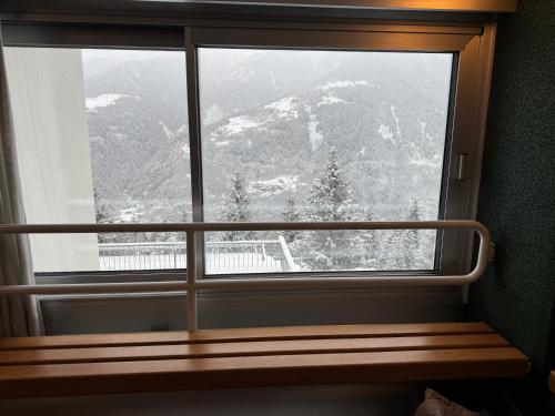 a window with a view of a snow covered mountain at Panorama Marilleva 1400 - Val di Sole in Marilleva