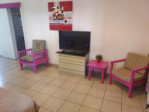 a living room with two chairs and a flat screen tv at Sea Apartments in Larnaka