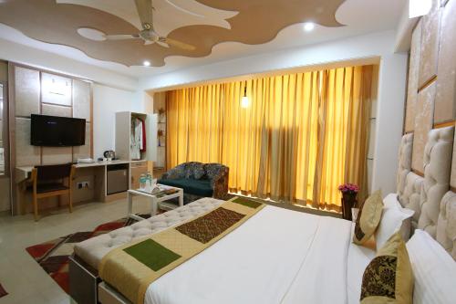 a hotel room with a large bed and a living room at Hotel Opera Delhi International Airport in New Delhi