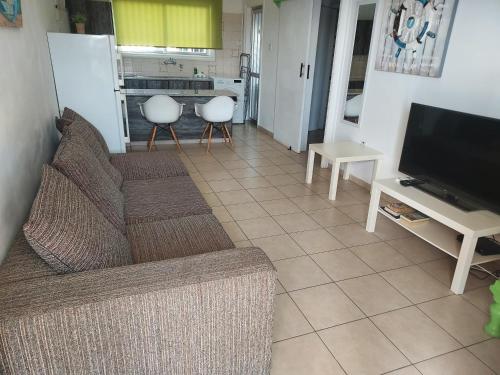 a living room with a couch and a television at Sea Apartments in Larnaka