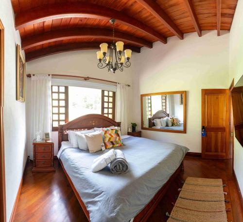 ein Schlafzimmer mit einem großen Bett mit Kronleuchter in der Unterkunft Autenthico Sajonia Hotel Aeropuerto in Rionegro