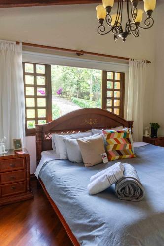 ein Schlafzimmer mit einem großen Bett mit einem großen Fenster in der Unterkunft Autenthico Sajonia Hotel Aeropuerto in Rionegro