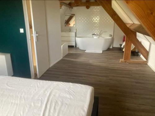 a bathroom with a bed and a tub and a sink at le chant des Verdiers in Saint-Aubin-de-Nabirat