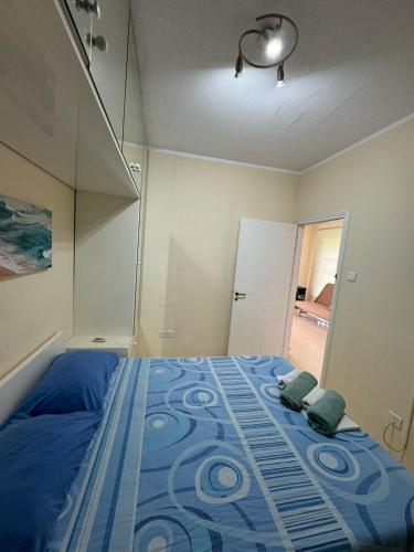 a bedroom with a blue bed with two pillows on it at Sea Apartments in Larnaka
