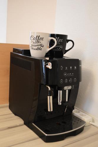 a coffee maker with two cups on top of it at Gemütliche Ferienwohnung - Prein an der Rax in Prein an der Rax