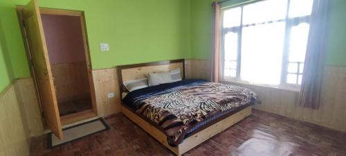 a bedroom with a bed in a room with a window at Kunjung palter home stay in Kaza