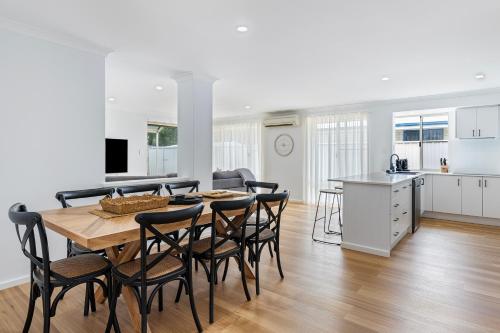 a kitchen and dining room with a table and chairs at Stylish 5-Bedroom Home Geographe in Geographe