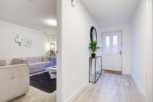 a white living room with a couch and a mirror at Entire house in Stanway, Colchester in Colchester