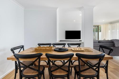 a dining room with a table and four chairs at Stylish 5-Bedroom Home Geographe in Geographe