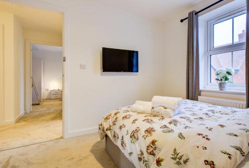 a bedroom with a bed and a tv on a wall at Entire house in Stanway, Colchester in Colchester