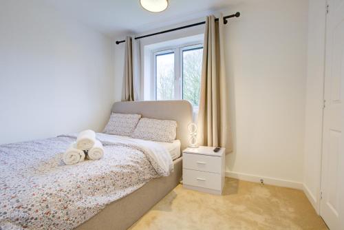 a bedroom with a bed with two towels on it at Entire house in Stanway, Colchester in Colchester
