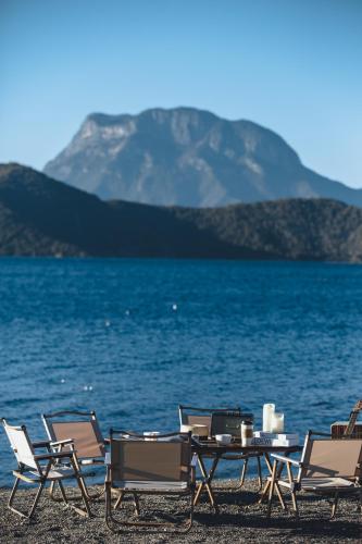 a group of chairs and a table on the beach at Lakeside Retreat - LuguLake Lijiang in Zuosuo