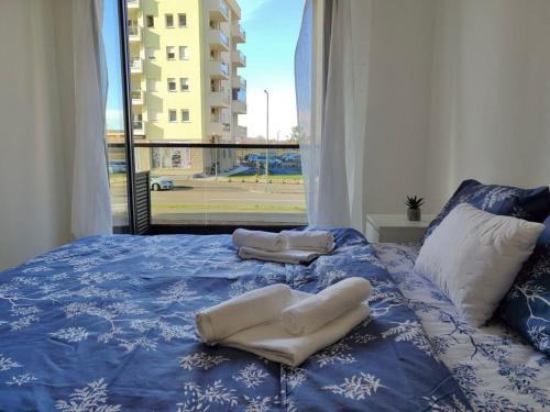 a bed with two towels on it with a window at apartman Sara in Trebinje