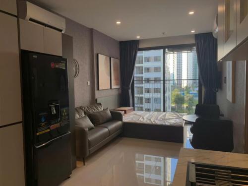a living room with a couch and a bed and a window at CĂN HỘ VINHOMES GRAND PARK QUẬN 9 Studio in Gò Công