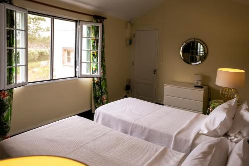 a bedroom with two beds and a window at Casa Villa Garden in Ponta Delgada