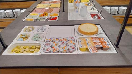 a table with several trays of food and a cake at Hotel Restaurant Schwartz in Neusiedl am Steinfelde