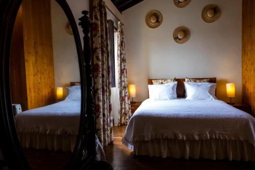 a bedroom with two beds and a mirror at Casa Villa Garden in Ponta Delgada