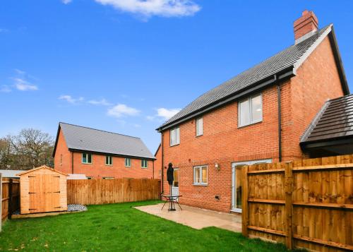 a red brick house with a wooden fence at Entire house in Stanway, Colchester in Colchester