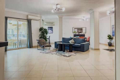 a living room with a blue couch and a table at Distinct & Decent 2 BDR Apt Steps From Nightlife and Airport in Cairo